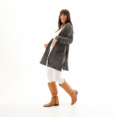 Modelo luciendo un spolverino gris Salma, con pantalones blancos y botas marrones, posando en un fondo blanco.