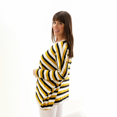 Sweater Ambar Rayas con franjas amarillas y negras, modelo femenino sonriendo de perfil.