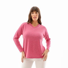 Sweater Catalina de color rosa con escote en V y detalles brillantes en el cuello, modelo posando
