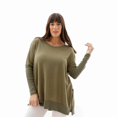 Modelo luciendo un suéter Dafne de color verde oliva, con un diseño suelto y cómodo.