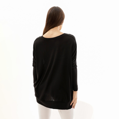 Modelo de espaldas vistiendo un sweater negro Dafne, con un diseño amplio y mangas largas.