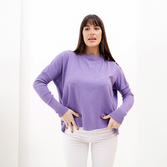 Modelo vistiendo un sweater morado de manga larga y cuello redondo, posando frente a un fondo blanco.