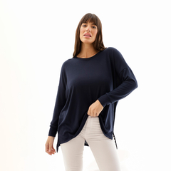 Modelo usando un sweater azul marino con mangas largas y corte suelto.