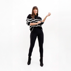 Modelo luciendo un sweater Holanda de rayas negras y blancas, combinado con pantalones negros y botas.