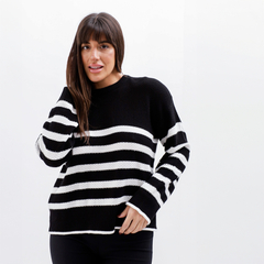 Modelo usando un sweater de rayas negras y blancas, con un diseño moderno y cómodo.