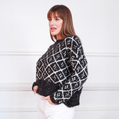 Modelo usando un suéter negro y blanco con diseño de rombos, ideal para el invierno.