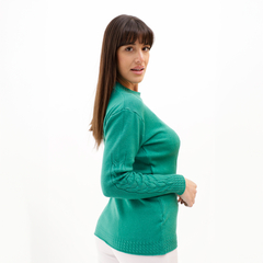 Modelo luciendo un suéter verde con detalles en las mangas.
