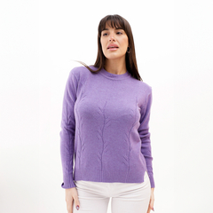 Una mujer modelando un sweater de color lila con un diseño de trenzas en el frente.