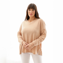 Modelo vistiendo un sweater color nude con detalles en los laterales, ideal para un look casual.