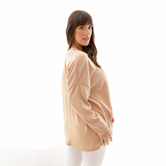 Modelo luciendo un sweater de color beige, con un diseño moderno y mangas amplias.