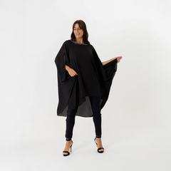 Túnica negra con aplique, diseñada para ocasiones elegantes, modelada por una mujer sonriente.