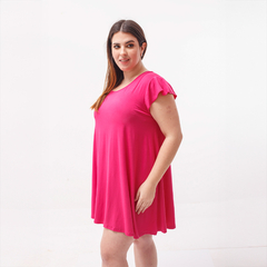 Vestido básico de color rosa, con mangas cortas y corte suelto, modelado por una mujer.