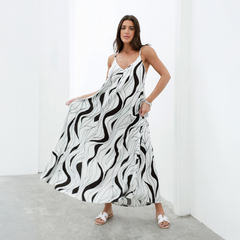 Model luciendo un vestido largo de estampado en blanco y negro con diseño ondulado.
