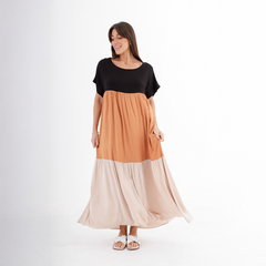 Vestido largo Elita en tonos negro, naranja y beige, con una mujer sonriendo mientras lo muestra.
