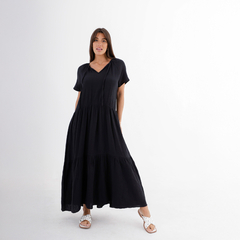 Vestido largo de color negro con mangas cortas y diseño de volantes, usado por una modelo en un fondo blanco.