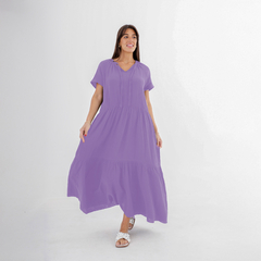Modelo luciendo un vestido largo morado con mangas cortas y un diseño de volantes.