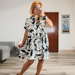 Vestido Griselda con diseño en blanco y negro, modelo corto con mangas, luciendo una mujer que se toma una selfie en un ambiente luminoso.
