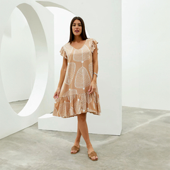 Modelo luciendo un vestido Isadora de color beige con estampado de hojas, con mangas rizadas y falda con volados.