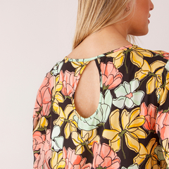 Vista trasera del vestido Juani, con estampado floral en tonos cálidos y detalle de escote en forma de óvalo.