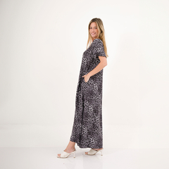 Modelo luciendo un vestido largo de estampado de leopardo, con bolsillos, en un fondo blanco.