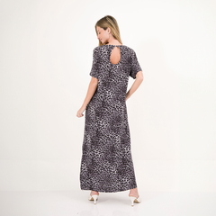 Modelo usando un vestido largo de estampado de leopardo, mostrando la parte trasera con un corte en la espalda.