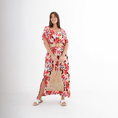Modelo luciendo un vestido largo de flores con cinturón y bolso de mimbre.