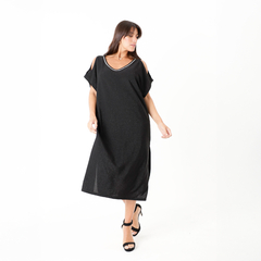 Modelo luciendo un vestido negro largo con detalles brillantes y hombros descubiertos, complementado con sandalias de tacón.