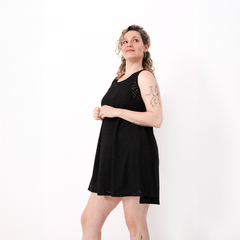 Vestido Magui negro con diseño de calado, modelo de pie sonriendo.