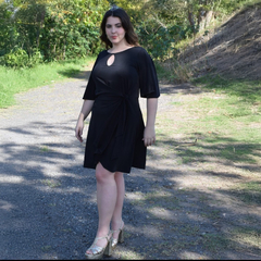 Modelo luciendo un vestido negro Maná con un diseño elegante y parte superior con corte en forma de óvalo.