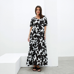 Vestido Nuez de estampado floral en blanco y negro, con mangas cortas y corte largo, presentado por una modelo en un fondo blanco.