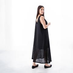 Vestido largo negro con detalles de encaje, modelo luciendo el vestido de espaldas en un fondo blanco.