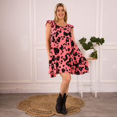 Vestido Sia rosa con estampado de manchas negras, modelo con tirantes y corte fluido, combinado con botas negras.