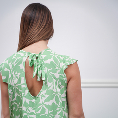 Vista trasera del vestido Sia, verde con estampado de hojas y detalle de lazo en la parte superior.