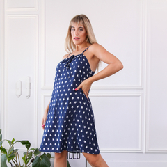 Modelo luciendo un vestido azul con estampado de estrellas blancas, en un entorno luminoso y minimalista.