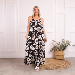 Vestido largo Trini con estampado floral en blanco y negro, lucido por una modelo en un ambiente luminoso.