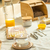 Mesa posta com kit de bambu, incluindo queijo coberto, bebidas e utensílios.