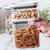 Pote hermético organizador retangular com pasta integral e pistaches, ideal para armazenar alimentos.