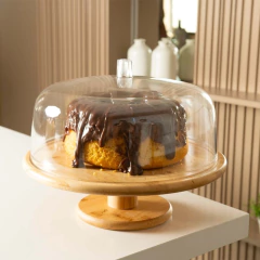 Boleira Sense com cúpula de vidro e pé de bambu, exibindo um bolo com cobertura de chocolate.