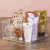 Organizador multiuso transparente com frascos de perfume e produtos cosméticos.