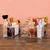 Conjunto de organizadores multiuso em acrílico com produtos de beleza e perfumes.