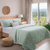 Habitación con cama vestida con set de 2 piezas Cover 1 1/2 Plaza y funda Vega Jean Cartier en color verde.