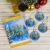 Saquinho dos bons desejos decorado com ornamentos natalinos e tags de sentimentos como fé, paz, amor e união.