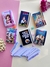 Conjunto de mini bíblias ilustradas com versículos, incluindo temas como família, jovens e crianças, dispostas em uma superfície colorida.