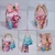 Caixinhas de festa decoradas com personagens dos Três Porquinhos, incluindo uma laço rosa e árvores de papel.