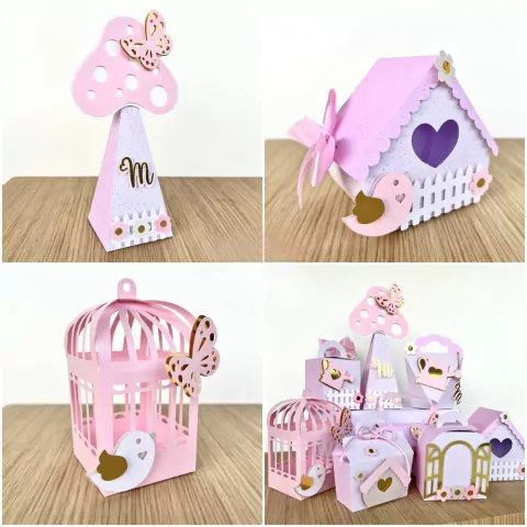 Modelo de decoração para festas com itens em papel, incluindo um cogumelo rosa, uma casinha encantada, uma gaiola e várias caixinhas decorativas, todas em tons de rosa e dourado.