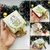Caixa de brigadeiro decorada para o Natal, com laço dourado e ilustrações festivas, mostrando diferentes ângulos do produto.