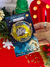 Cartão de Natal em formato de meia esfera com imagem do nascimento de Jesus e um bombom dentro, decorado com estrelas e cores natalinas.