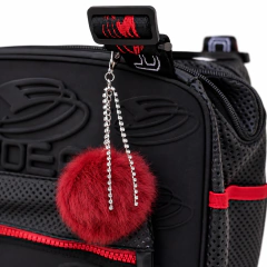 Detalle del bolso EDEA Cube negro con llavero de pompón rojo y bolsillo frontal