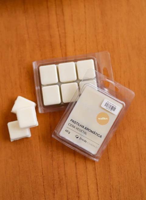 Pastilha aromática branca em cera vegetal Waffles de 40g em embalagem plástica transparente sobre superfície de madeira