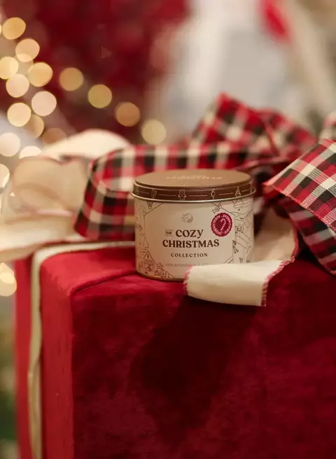 Vela aromática Peppermint 330g da coleção The Cozy Christmas sobre presente vermelho com fita xadrez